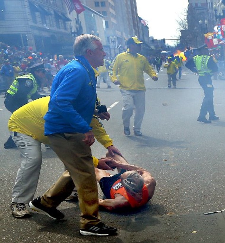 A second explosion goes off (rear) as a runner was blown to the ground by the first explosion near the finish line of the 117th Boston Marathon. (Photo by John Tlumacki/The Boston Globe via Getty Images)