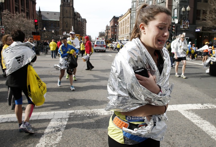 An unidentified Boston Marathon runner leaves the course crying near Copley Square following an explosion in Boston Monday, April 15, 2013. (AP Photo/Winslow Townson)