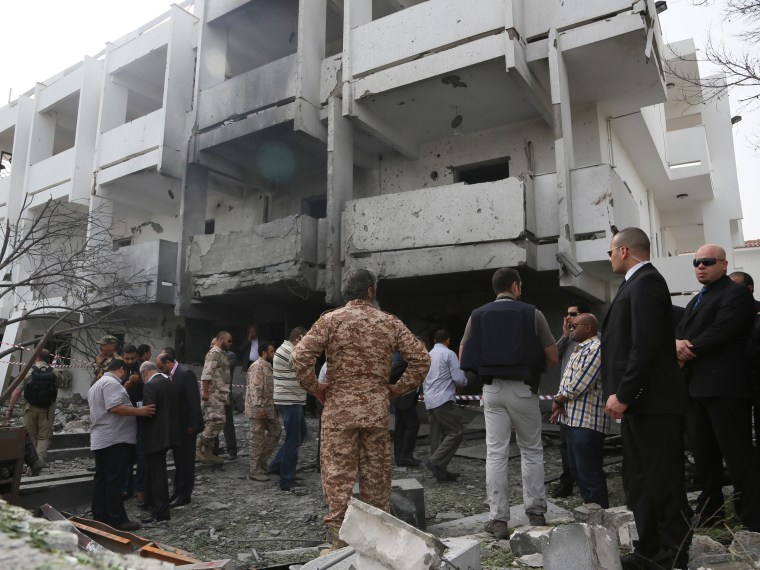Security officers and officials inspect the site of a car bomb that targeted the French embassy wounding two French guards and causing extensive material damage in Tripoli, Libya, Tuesday, April 23, 2013. (Photo by Abdul Majeed Forjani/AP Photo)