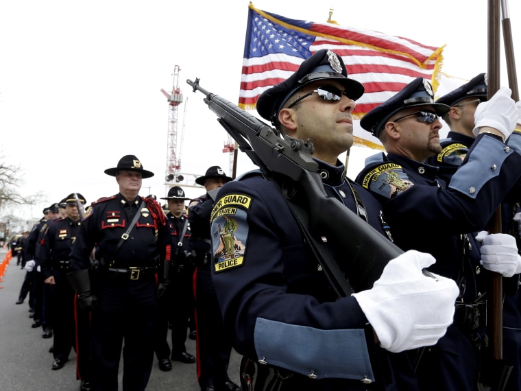 Members of a police honor guard, front, lead a column of law enforcement officials into a memorial service for fallen Massachusetts Institute of Technology police officer Sean Collier, in Cambridge, Mass., Wednesday, April 24, 2013. Collier was fatally...
