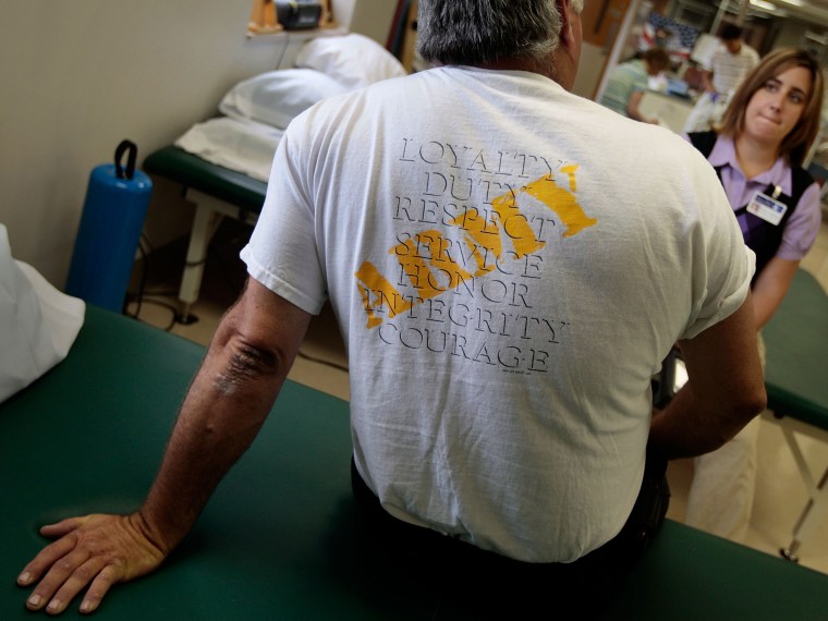 File Photo: Robert Wake (L), an Iraq war veteran suffering from posttraumatic stress disorder (PTSD), talks to physical therapist Nicole Bormann before a session in the VA Medical Center August 10, 2009 in St Louis, Missouri. Wake served in the MP ...