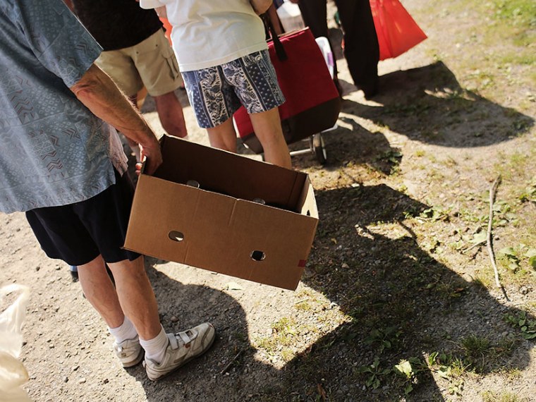 People wait in line with boxes to carry food during a food distribution by the Food Bank of the Southern Tier Mobile Food Pantry on June 20, 2012 in Oswego, New York. (Photo by Spencer Platt/Getty Images)