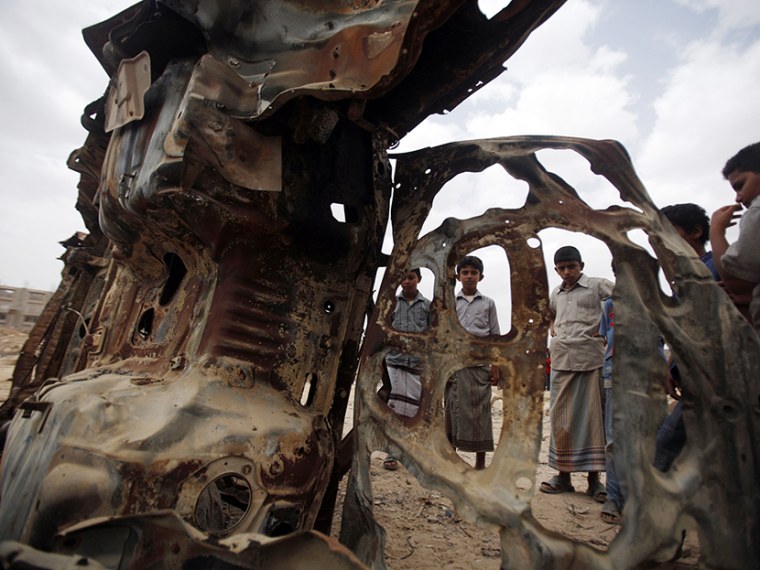 Boys gather near the wreckage of car destroyed last year by a U.S. drone air strike targeting suspected al Qaeda militants in Azan of the southeastern Yemeni province of Shabwa February 3, 2013. (Photo by Khaled Abdullah/Reuters)