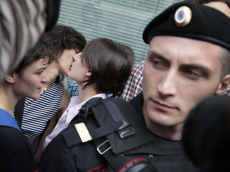 Gay rights activists kiss near the State Duma, Russia's lower parliament chamber, next to a police officer in Moscow on Tuesday, June 11, 2013.. (Photo by Ivan Sekretarev/AP)