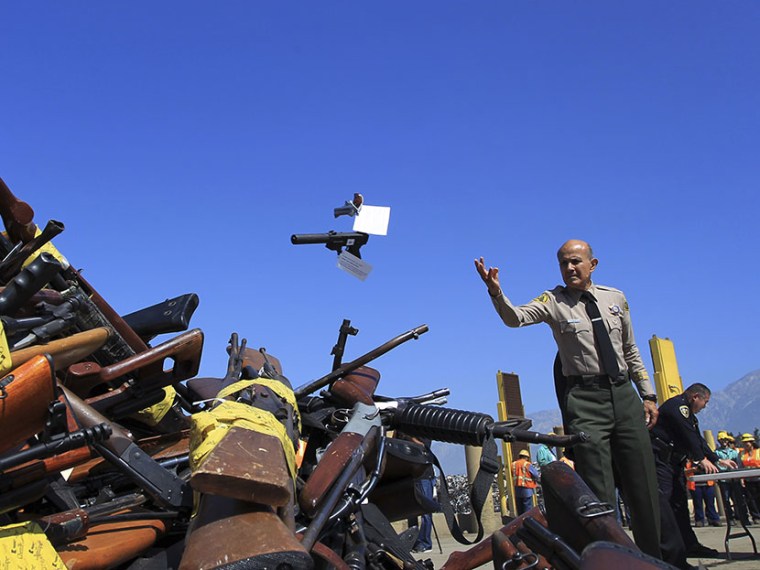 Los Angeles County Sheriff Lee Baca tosses a pistol onto a pile of guns to be melted at the Los Angeles County Sheriff's Department's 20th annual Gun Melt at the Gerdau Steel Mill in Rancho Cucamonga, California, July 30, 2013. Thousands of weapons...