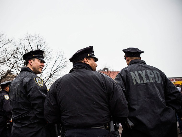 New York Police Department officers monitor a march against stop-and-frisk tactics used by police on February 23, 2013 in New York City.  (Photo by Andrew Burton/Getty)