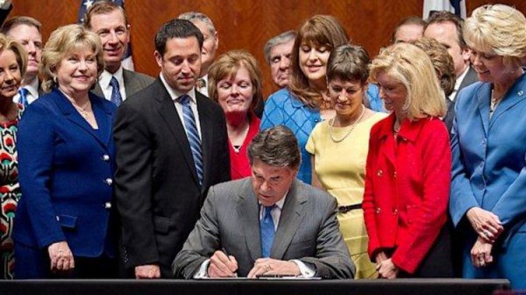 Texas Gov. Rick Perry (R) signs restrictions on reproductive rights into law in July.
