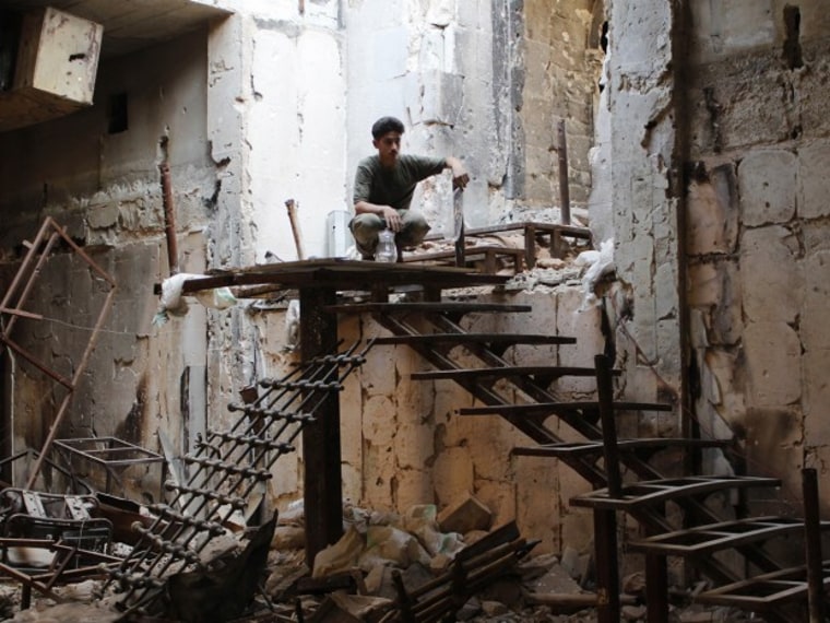 A Free Syrian Army fighter sits atop a flight of stairs near the Grand Umayyad mosque in Aleppo