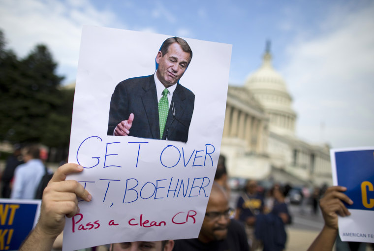 A protestor holds a sign calling on House Speaker John Boehner to pass a clean continuing budget resolution during an event on Capitol Hill in Washington, Friday, Oct. 4, 2013.