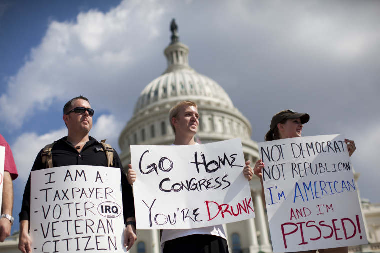 Protestors holds signs against the government shutdown on the West Front of the U.S. Capitol building on Capitol Hill on Friday, Oct. 4, 2013 in Washington.