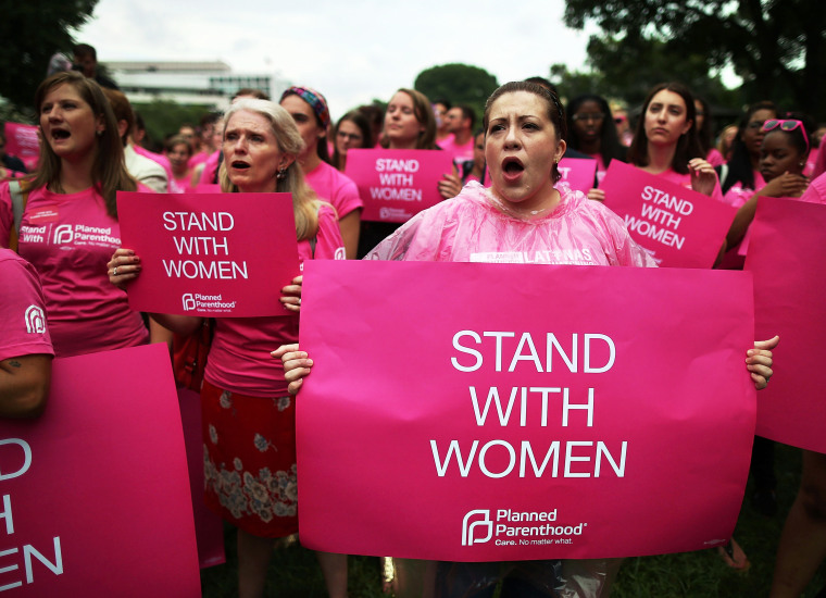 Women hold up signs during a women's pro-choice rally on Capitol Hill, July 11, 2013.