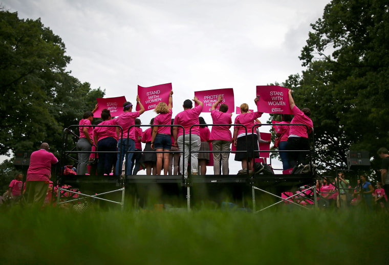 People hold up signs during a women's pro-choice rally on Capitol Hill, July 11, 2013 in Washington, DC.
