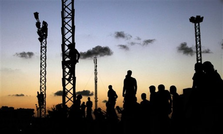 Libyans climb up electricity towers to watch the march against Ansar al-Shariah Brigades and other Islamic militias, in Benghazi, Libya, Friday, Sept. 21,...