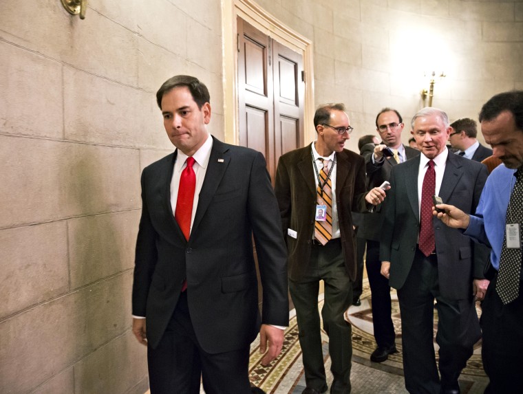 Sen. Marco Rubio passes as Sen. Jeff Sessions talks with reporters on Capitol Hill in Washington, Friday, Oct. 11, 2013.
