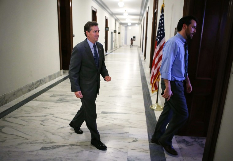 U.S. Senator Jim DeMint enters his office with his communications director Wesley Denton December 6, 2012 on Capitol Hill in Washington, DC.