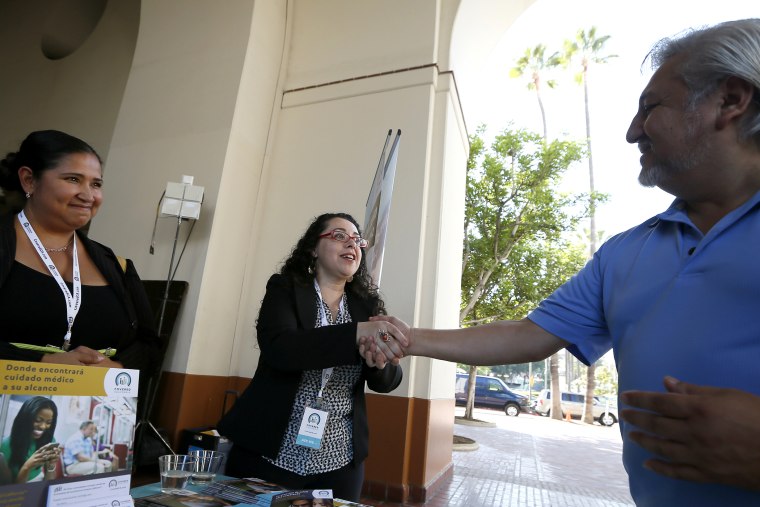 People sign up for health insurance information at a Covered California event in Los Angeles
