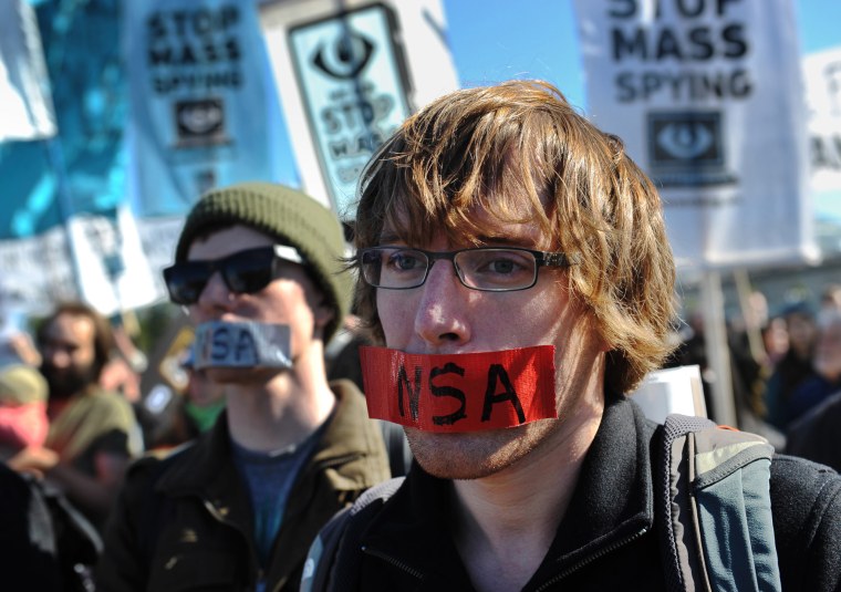 Demonstrators with tape over their mouths take part in a protest against government surveillance on October 26, 2013 in Washington, DC.