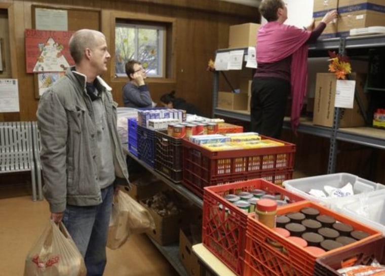 Larry Bossom, left, 41, who lost his job a few month ago, visits the St. Ignatius food pantry in Chicago, Friday, Nov. 1, 2013.