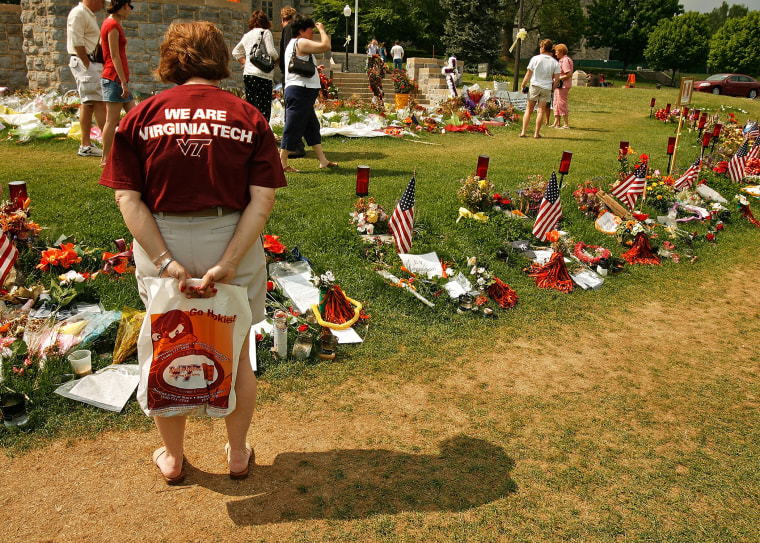 People walk along the edge of a memorial for the victims of the shooting at Virginia Tech, May 11, 2007, in Blacksburg, Virginia.