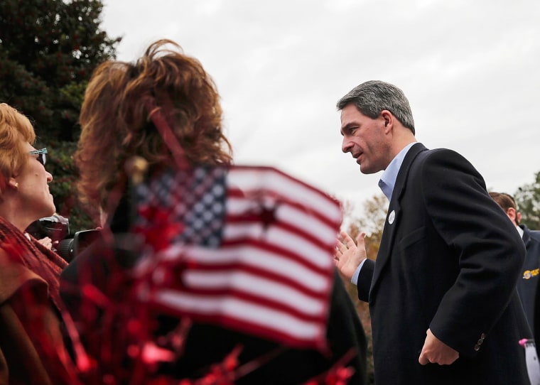 Virginia Attorney General Ken Cuccinelli talks with supporters while greeting voters on Election Day, November 5, 2013 in Mechanicsville, Virginia.