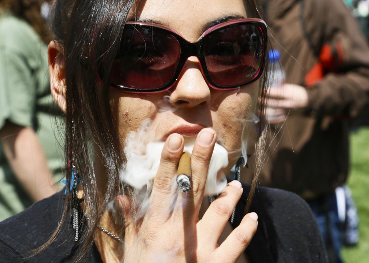 A woman smokes a blunt at the 4/20 marijuana holiday in Civic Center Park in downtown Denver April 20, 2013.