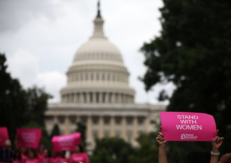 Women hold up signs during a women's pro-choice rally on Capitol Hill, July 11, 2013 in Washington, DC.