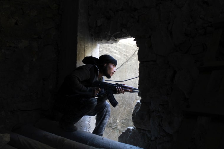 A Free Syrian Army fighter kneels with his weapon in Aleppo's Karm al-Jabal district