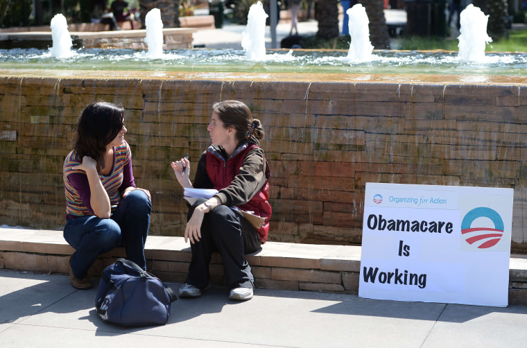 An Affordable Healthcare Act supporter (R) talks with a student (L) about the law on the campus of Santa Monica City College in Santa Monica, California, October 10, 2013.