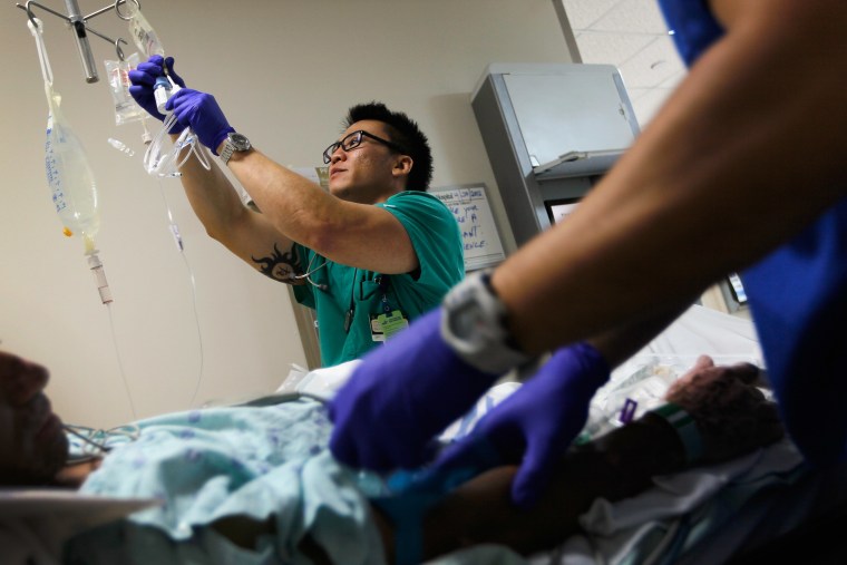A nurse hangs an I.V. bag for a patient at the University of Miami Hospital, April 30, 2012.