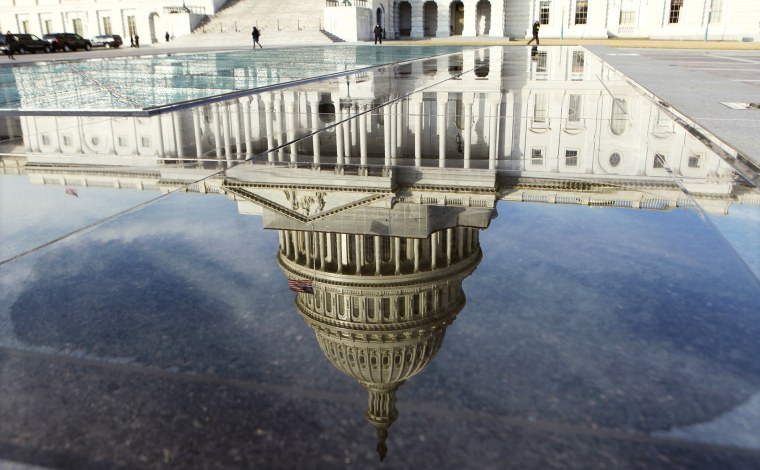 The dome of the Capitol is reflected in a puddle in Washington, Feb. 17, 2012.