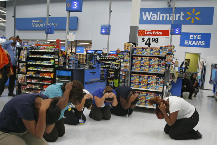 Walmart employees practice the drop, cover, and hold on technique during the \"Great ShakeOut\" \" earthquake drill at Walmart in Torrance, California October 17, 2013.