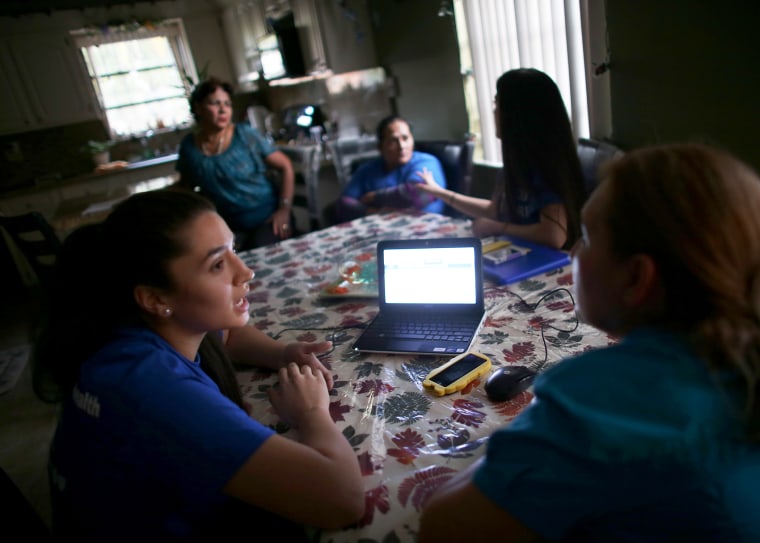 Insurance agent Janelle Arevalo makes a house call to sign up Sandra Berrios for a plan under the ACA in Miami, Nov. 14, 2013.