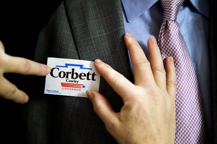A supporter of Pennsylvania Gov. Tom Corbett places a campaign sticker, Nov. 7, 2013.