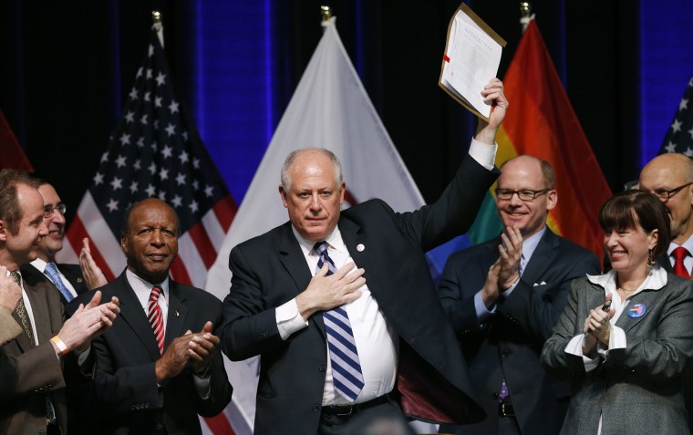 Illinois Governor Pat Quinn holds up the Religious Freedom and Marriage Fairness Act after signing it into law at a ceremony in Chicago, Illinois, November 20, 2013.