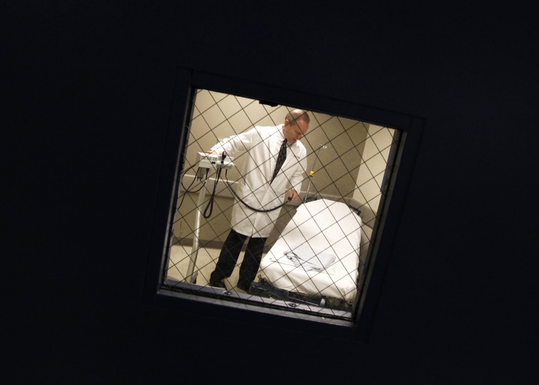 Dr. William Sullivan, a physician at the University of Illinois at Chicago hospital, is seen through a re-enforced window of a psychiatric evaluation room, Dec. 21, 2011.