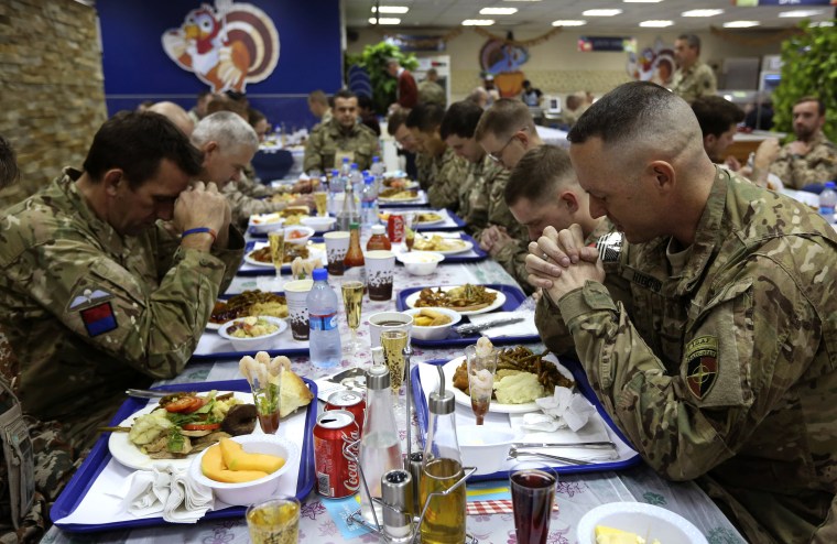 U.S. troops pray before eating during a Thanksgiving meal at a NATO base in Kabul