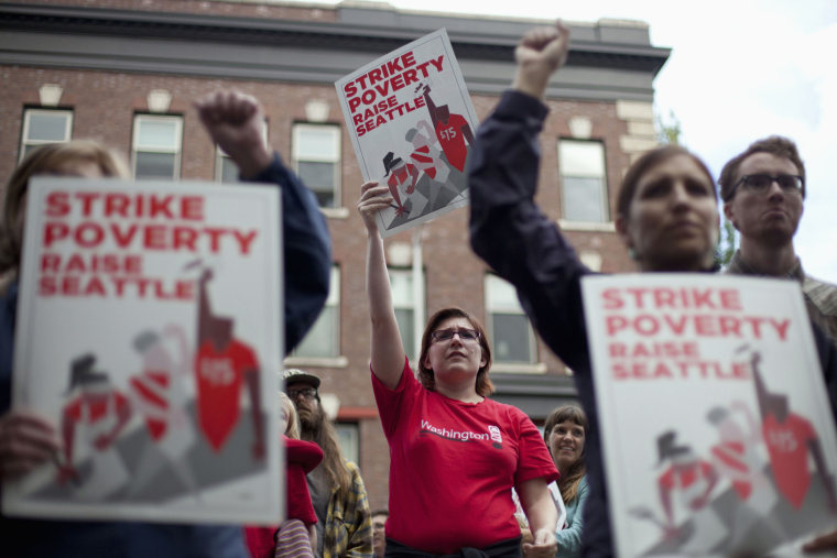 Joelle Craft (C) holds a sign during a rally and strike aimed at the fast-food industry and the minimum wage in Seattle, Washington August 29, 2013.