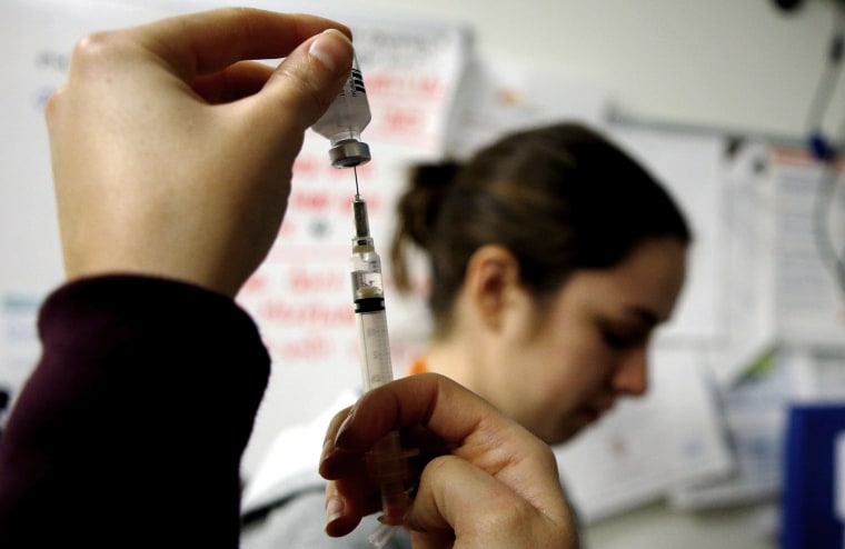 Nurses prepare influenza vaccine injections during a flu shot clinic in Boston