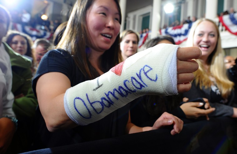 Cathey Park shows her bandaged hand written \"I love Obamacare\" as she waits to hear US President Barack Obama speaking on healthcare at the Faneuil Hall in Boston, Mass., on Oct. 30, 2013.