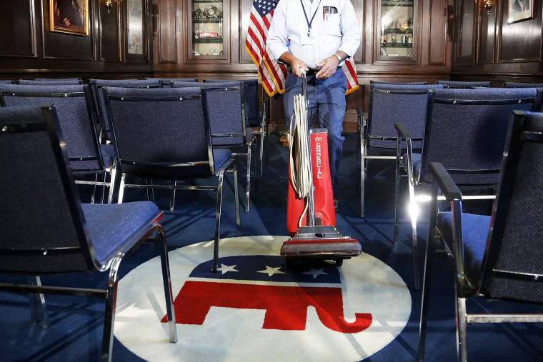 A worker prepares a room before a news conference by GOP leaders at the RNC offices in Washington, Oct. 23, 2013.