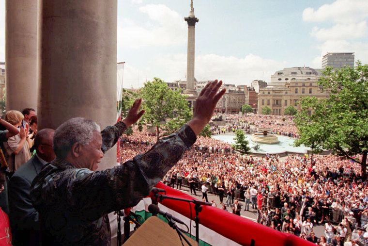 South African President Nelson Mandela acknowledges the cheers of the vast Trafalgar Square crowd from the balcony of South Africa House in London, July 12 1996.