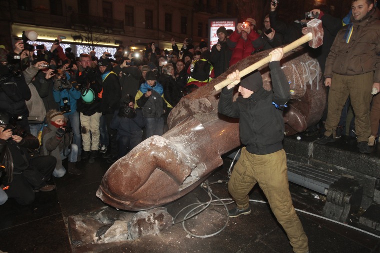 An anti-government protester beats the statue of Vladimir Lenin with a sledgehammer in Kiev, Ukraine on Dec. 8, 2013.