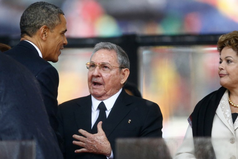 Barack Obama greets Cuban President Raul Castro before giving his speech, as Brazil's President Dilma Rousseff looks on, at the memorial service for Nelson Mandela, Dec. 10, 2013.