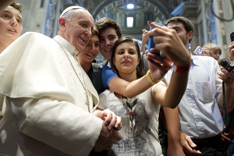 Pope Francis poses with youths during a meeting with the Piacenza diocese in Saint Peter's Basilica, AUg. 28, 2013.