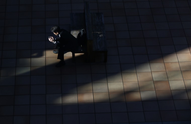 A man uses a smartphone on a street in Tokyo