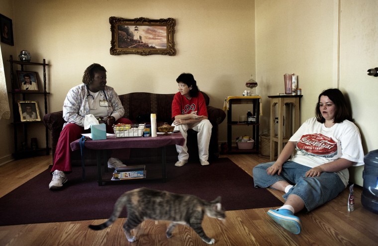 Nurse and home healthcare worker Claudia Cox visits with Regina Higgins, 45, in Jackson, Miss., June 1, 2012.