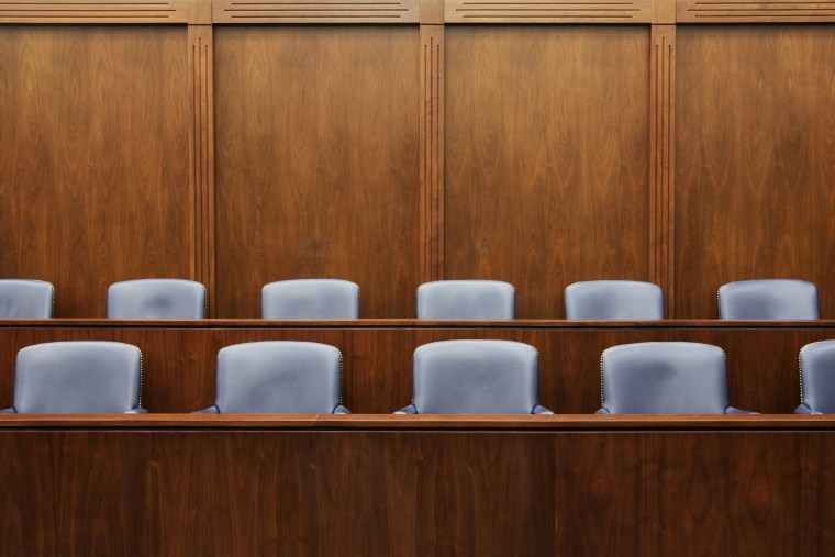 Empty jury seats in a courtroom.
