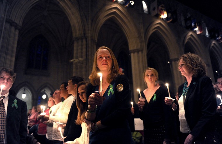 Miranda Pacchiana, center, of Newtown, Conn., holds a candle at the conclusion of a vigil to remember those who lost their lives because of gun violence on Thursday, Dec. 12, 2013 at the National Cathedral in Washington, D.C.