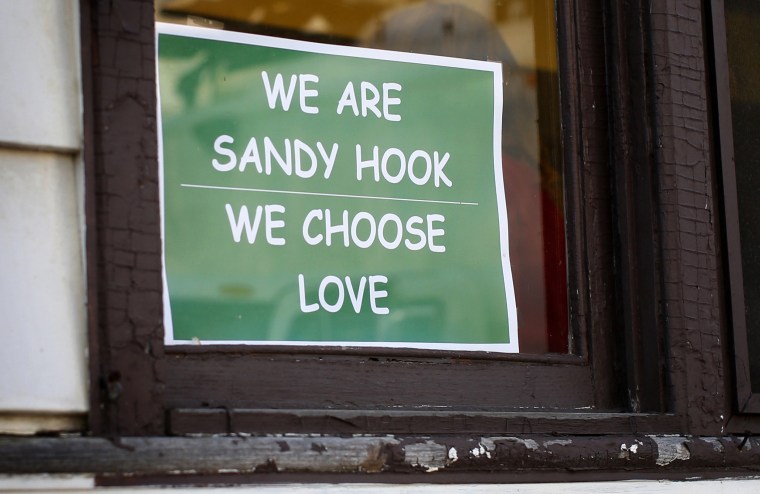 A sign hangs in a window of the Sandy Hook Diner in Newtown, Conn.