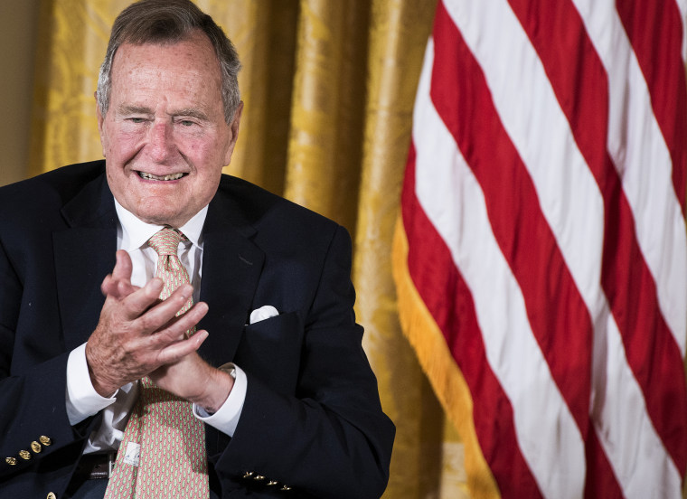 Former US President George H. W. Bush applauds during an event in the East Room of the White House July 15, 2013 in Washington, DC.
